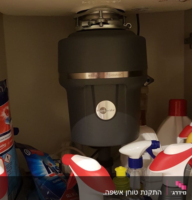 מכשיר טוחן אשפה מותקן מתחת לכיור במטבח